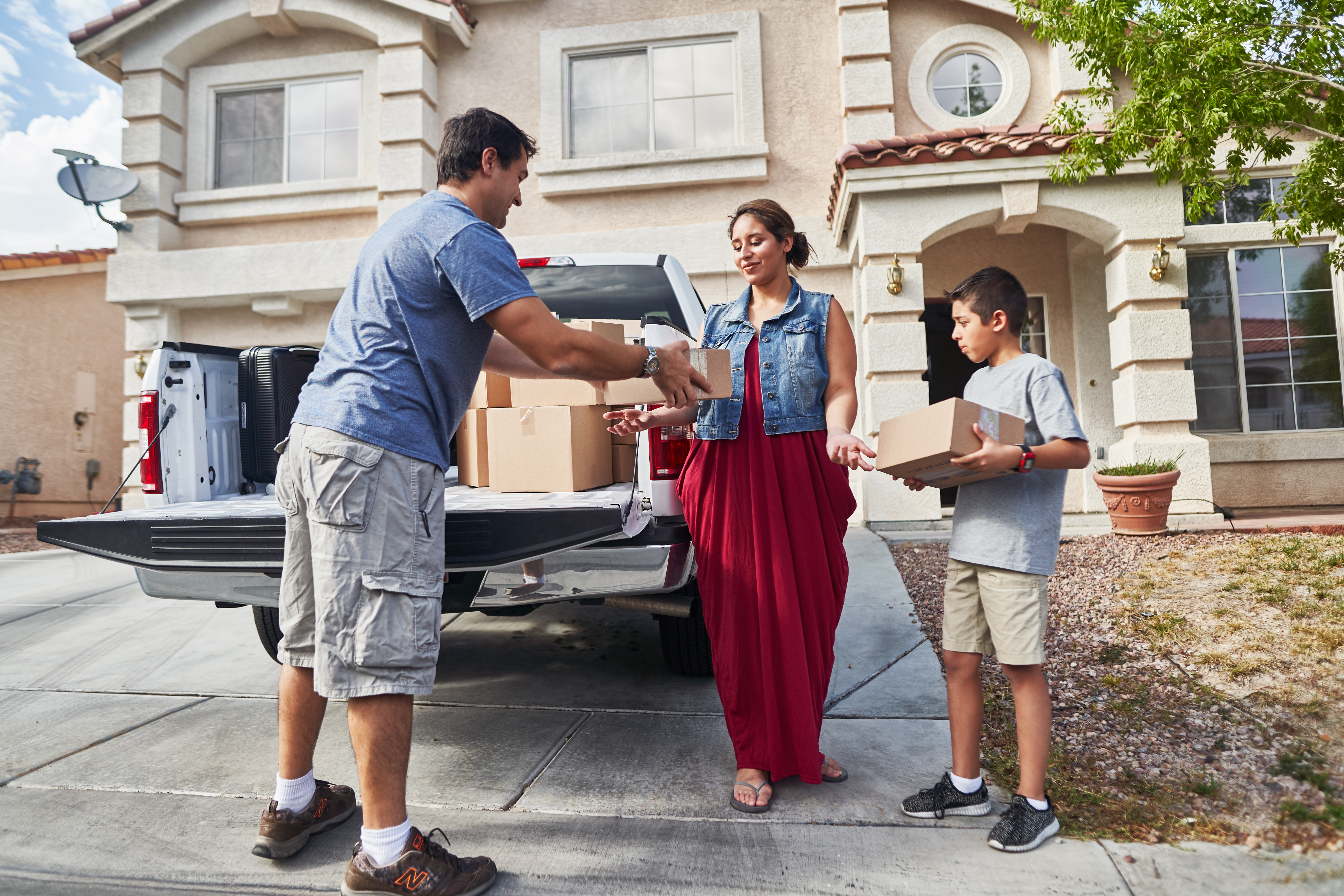hispanic family unloading pickup truck and moving into new house in las vegas